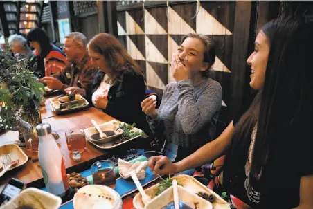  ?? Photos by Yalonda M. James / The Chronicle ?? Lauren Michardi (above, center) and Kaijah Robertson at a Saturday dinner at the Cafe Ohlone pop-up at University Press Books in Berkeley. Left: A soft-boiled quail egg gets peeled.
