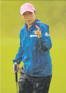  ?? Andy Buchanan / AFP / Getty Images ?? I.K. Kim had no problem navigating her way through a rainy day in St. Andrews, Scotland, leaving with a two-shot lead.