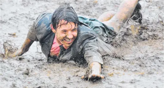  ?? Photos Paula Barrington ?? Looks like fun - a mud runner speeds down the mud slide at the Flemington Mud Run.