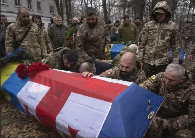 ?? (AP/Efrem Lukatsky) ?? Volunteers of the Georgian Legion pay last respects at the coffins of their comrades Nodar Nasirov, 28, and Georgia Gogilashvi­li, 40, who were killed in a battle against Russian troops, during a funeral ceremony Tuesday in Kyiv, Ukraine. The Georgian Legion is a military unit formed mainly by ethnic Georgian volunteers.