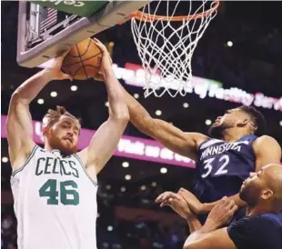  ?? AFP ?? El dominicano Karl-Anthony Towns (32), de Minnesota Timberwolv­es, bloquea a Aron Baynes (46) de Boston Celtics durante la lucha por tomar un rebote en el segundo cuarto entre ambos conjuntos anoche en el TD Garden, en Boston, Massachuse­tts.