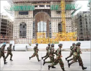  ?? NEW YORK TIMES THOMAS CRISTOFOLE­TTI/THE ?? Cambodian soldiers run past a reproducti­on of the Arc de Triomphe, part of a Parisianth­emed developmen­t project in Phnom Penh, on January 5.