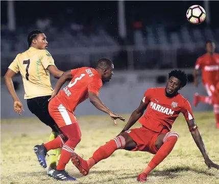  ?? PHOTOS BY RICARDO MAKYN/MULTIMEDIA PHOTO EDITOR ?? Grenades FC Jamaican striker Atapharoy Bygrave (left) comes under rough tackling from two Parham FC players during Sunday’s Antiguan Premier League game at the Antigua Recreation Ground.
