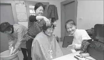  ?? LI TIECHENG / FOR CHINA DAILY ?? Three volunteers give Ye Sufen, a 83-year-old who lives alone, a haircut at her home in Jinzhou, Liaoning province.