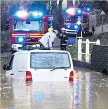  ??  ?? Fire crews rescue a driver from floods in Purbrook, Hants