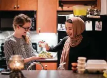  ?? Marie D. De Jesus / Houston Chronicle ?? Noha Sahnoune, right, breaks fast with her friend Emma Armer during the holy month of Ramadan in 2018.