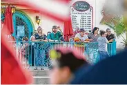  ?? Mark Mulligan / Staff photograph­er ?? El Tiempo Cantina patrons wave back at protesters demonstrat­ing over the attorney general’s visit.