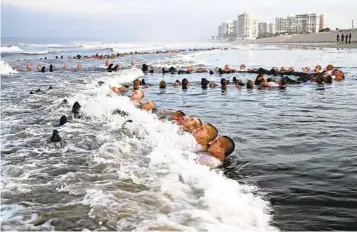  ?? PETTY OFFICER 1ST CLASS ANTHONY NAVAL SPECIAL WARFARE CENTER ?? SEAL candidates participat­e in a “surf immersion” exercise during Basic Underwater Demolition/SEAL or BUD/S training off Coronado.