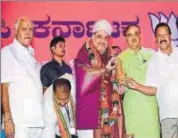  ?? PTI FILE ?? BJP president Amit Shah being felicitate­d with a Mysore peta at a meeting of party leaders in Bengaluru on Wednesday.