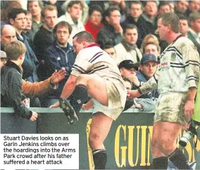  ??  ?? Stuart Davies looks on as Garin Jenkins climbs over the hoardings into the Arms Park crowd after his father suffered a heart attack