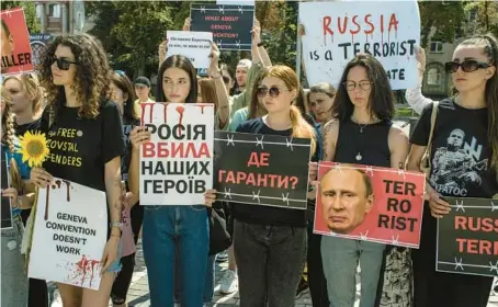  ?? LAURA BOUSHNAK/THE NEW YORK TIMES ?? Protesters in Kyiv call for action Saturday over POW deaths at a Russian detention site.