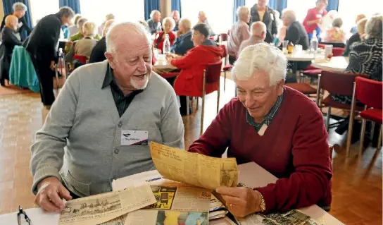  ??  ?? Former Timaru Main School pupils Tony McKenzie, left, and Dick Dodds check out old newspaper articles about the school at their four-yearly reunion, held at the South Canterbury RSA on Tuesday.