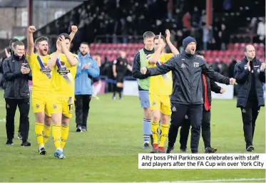  ??  ?? Alty boss Phil Parkinson celebrates with staff and players after the FA Cup win over York City