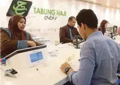  ??  ?? PENDEPOSIT berurusan di kaunter Tabung Haji.