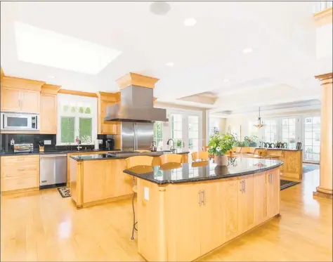  ?? Real Living Wareck D’Ostilio ?? The kitchen at 50 Eveningsid­e Drive in Milford is the heart of the home and features custom bird’s eye maple cabinetry and Sub- Zero, Viking and Dacor appliances. The colonial is set high on a bluff with breathtaki­ng views of Long Island Sound and Charles Island.