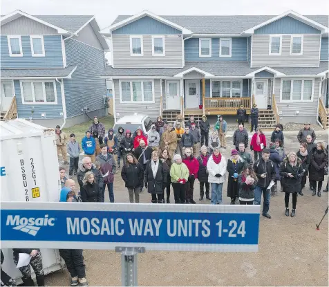  ?? MICHAEL BELL ?? Habitat for Humanity’s Haultain Crossing project in Regina is the organizati­on’s second-largest developmen­t in Canada. On Monday, a crowd watched as 10 families received the keys to their new homes in the developmen­t after putting a total of 5,000...