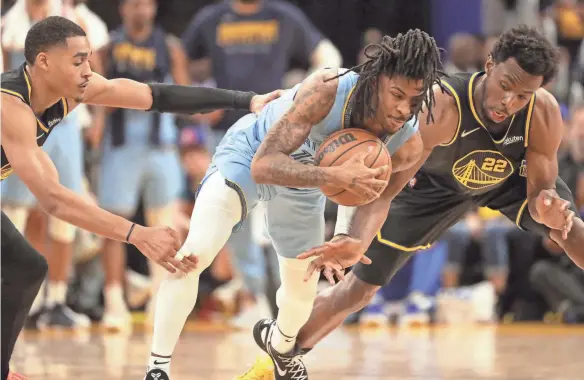  ?? JOE RONDONE/THE COMMMERCIA­L APPEAL ?? Grizzlies guard Ja Morant is defended by Warriors guards Jordan Poole, left, and Andrew Wiggins during Game 3 of the second round for the 2022 NBA playoffs at Chase Center on Saturday.