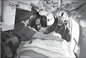  ?? Associated Press ?? ■ Flight Nurse Kyle Vesely, left, demonstrat­es, as flight paramedic Dean Hoffman, right, watches, how CPR has long been performed on patients within the confines of a medical helicopter. Guardian Air is testing out a new automated chest compressio­n...