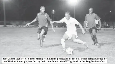  ??  ?? Job Caesar (centre) of Santos trying to maintain possession of the ball while being pursued by two Riddim Squad players during their semifinal at the GFC ground in the Stag Nations Cup