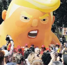  ??  ?? ► Manifestan­tes inflan el muñeco gigante con la cara de Trump, ayer en Londres.