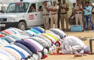  ?? PTI ?? Muslims offer Friday prayers under the protection of police personnel on a plot in Gurugram. —