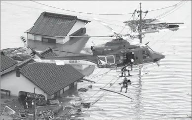  ?? KYODO VIA REUTERS ?? An aerial view shows a local resident being rescued from a submerged house by rescue workers using helicopter at a flooded area in Kurashiki, southern Japan, on Saturday.