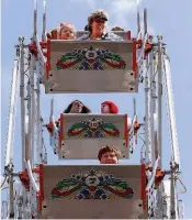  ?? ARKANSAS DEMOCRAT-GAZETTE FILE PHOTOS ?? LEFT: Miller Crosby of Ferndale feeds his goat, Pebbles, a chip from his nachos during the Arkansas Goat Festival in Perryville. RIGHT: Riders look out over the midway while riding the Ferris wheel during the Cabot Strawberry Festival in downtown Cabot.