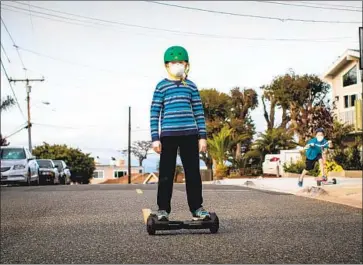  ?? Jay L. Clendenin Los Angeles Times ?? CHILDREN outfitted with masks play on a street in the Golden Hills neighborho­od of Redondo Beach.