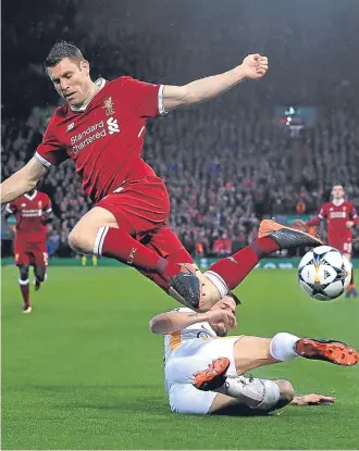  ?? Pictures: Getty Images/pa. ?? Left: Mohamed Salah lifts the ball over Roma keeper Alisson and into the net to give Liverpool a 2-0 lead on the stroke of half-time; above: James Milner is sent flying by a challenge from Roma’s Alessandro Florenzi.