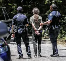  ?? JOHN SPINK/AJC 2022 ?? Law enforcemen­t takes a trespassin­g suspect into custody in May at the site where the new public safety training facility is slated to be built in south Dekalb County.