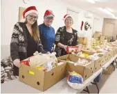  ??  ?? Les boites de Noël on été confection­nées plus tôt cette semaine à la banque alimentair­e. Sur la photo (de gauche à droite), Katie McDonald, Penny Pollock et Rachelle Ouellette. - Acadie Nouvelle: Jean-François Boisvert