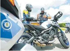  ?? FOTO: DPA ?? Kontrolle bei Gauingen: Polizisten kontrollie­ren die Papiere und die Maschine eines Motorradfa­hrers.