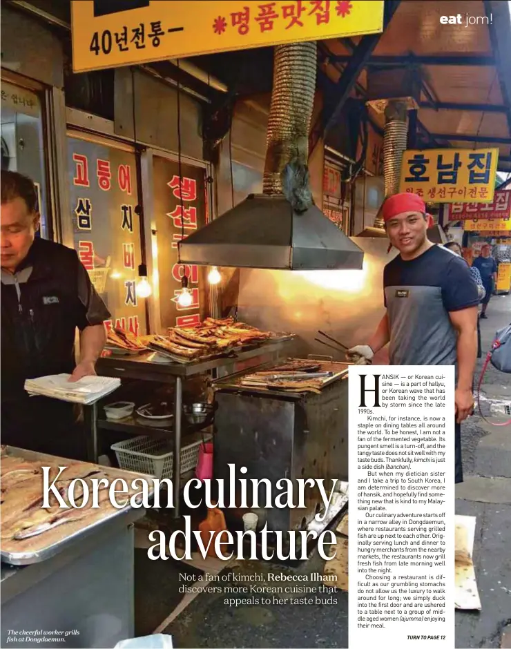  ??  ?? The cheerful worker grills fish at Dongdaemun.