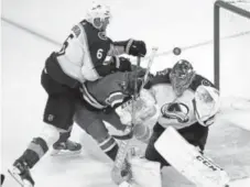  ?? Karl B. Deblaker, The Associated Press ?? Carolina’s Phillip Di Giuseppe collides with Semyon Varlamov and Erik Johnson on Saturday.