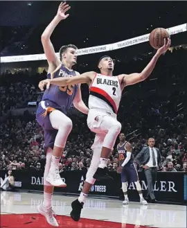  ?? Steve Dykes Associated Press ?? DRAGAN BENDER of Phoenix, guarding Portland’s Wade Baldwin, isn’t playing much. The Suns declined his option so he’ll be a free agent this summer.