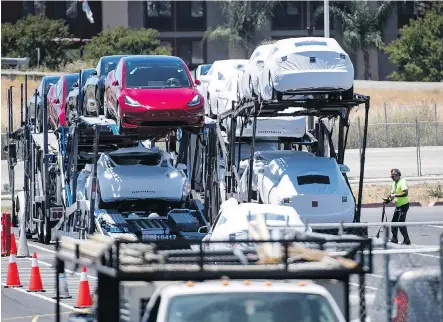  ?? DAVID PAUL MORRIS/BLOOMBERG ?? Tesla Inc. vehicles are loaded onto a truck for transport at the company’s manufactur­ing facility in Fremont, Calif., in June. Tesla is expecting to build up to 55,000 Model 3 units this quarter and has revived its goal to make 10,000 Model 3s a week...