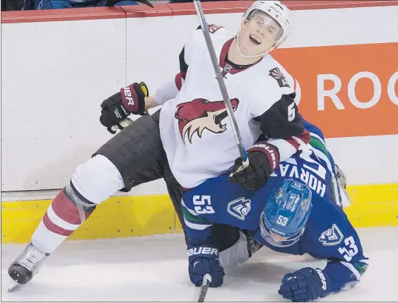  ?? — THE CANADIAN PRESS ?? Vancouver Canucks centre Bo Horvat fights for control of the puck with Arizona Coyotes defenceman Connor Murphy in the second period on Monday night. Horvat ended a 27-game goal drought, but the Canucks lost to the Coyotes 3-2.