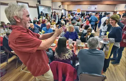  ?? Dan Watson/The Signal ?? Santa Clarita Valley Senior Center Executive Director Kevin MacDonald, left, takes a picture of volunteers as they serve some of the hundreds of attendees during the 2018 Thanksgivi­ng Feast and Party at the SCV Senior Center on Thursday.