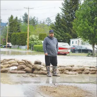  ?? NICK EAGLAND/The Province ?? Corey Kaden was in Penticton Thursday picking up sandbags when he got a call from his wife telling him they were getting evacuated from their home, pictured in background, near Brockie Place and 14th Avenue.