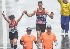  ?? OMAR RAWLINGS/GETTY IMAGES ?? Retired Bruins player Zdeno Chara nears the finish line as he holds hands with Becca Pizzi during the 2023 Boston Marathon.