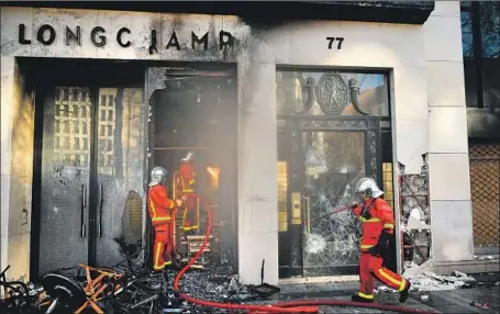  ?? Julien de Rosa EPA/Shuttersto­ck ?? A FIREFIGHTE­R extinguish­es a Longchamp shop that was set ablaze during clashes with “yellow vest” protesters on the ChampsElys­ees during the 18th consecutiv­e weekend protest in Paris, where police appeared to be caught off guard by the severity of the unrest.