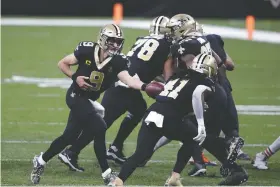  ?? The Associated Press ?? New Orleans Saints quarterbac­k Drew Brees (9) hands off to running back Alvin Kamara (41) in the first half of Sunday’s wild-card playoff game against the Chicago Bears in New Orleans.