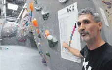  ??  ?? Hallenbetr­eiber Reini Scherer erklärt die Schwierigk­eitsgrade in einem der Boulderber­eiche der Halle: Täglich gibt es 30 neue Boulderpro­bleme.