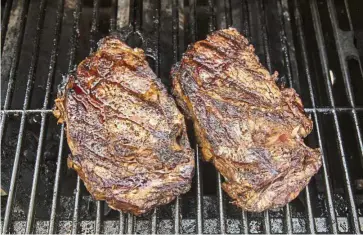  ??  ?? Rib-eye steaks brushed with mayonnaise and seasoned with salt and pepper, to be served with grilled potato brushed with mayonnaise and seasoned with parmesan, garlic and rosemary. — TNS