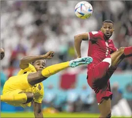  ?? Ariel Schalit Associated Press ?? FÉLIX TORRES, left, of Ecuador attempts a scissor kick as Abdulaziz Hatem of Qatar tries to defend. Qatar is the first host nation to lose its opening match.