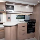  ??  ?? The sizeable peninsula unit in the kitchen neatly separates the galley from the lounge