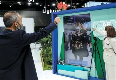  ?? ZHANG CHENG / XINHUA ?? A visitor (left) tries augmented reality technology during the Mobile World Congress in Barcelona, Spain, on June 28.