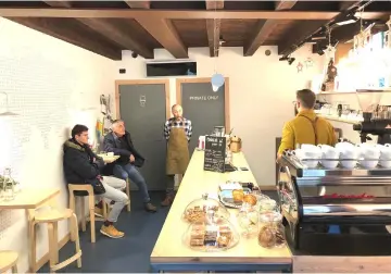  ??  ?? Matteo Campeotto, the barista at LABB Caffettin, right, and owner Michele Carisi, centre, banter with customers.