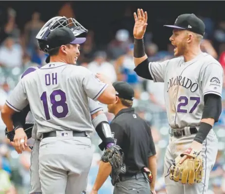  ?? Morry Gash, The Associated Press ?? Rockies shortstop Trevor Story congratula­tes Seunghwan Oh on his first save in a Colorado uniform Sunday in Milwaukee. Story had a three-run homer and four RBIs, and Oh pitched the final three outs in the Rockies’ 5-4 victory in 11 innings.