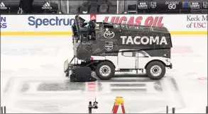  ?? Mark J. Terrill / Associated Press ?? A Zamboni resurfaces the ice after a Dec. 2 game between the Kings and Flames in Los Angeles. On game days, the Kings use 800 to 1,200 gallons of water to maintain the ice.